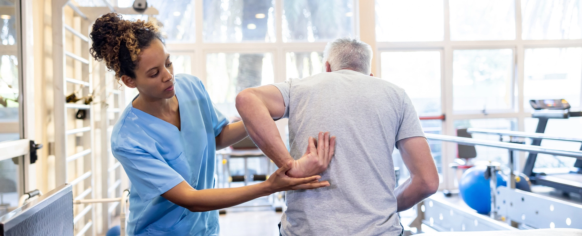 A therapist helps an elderly patient